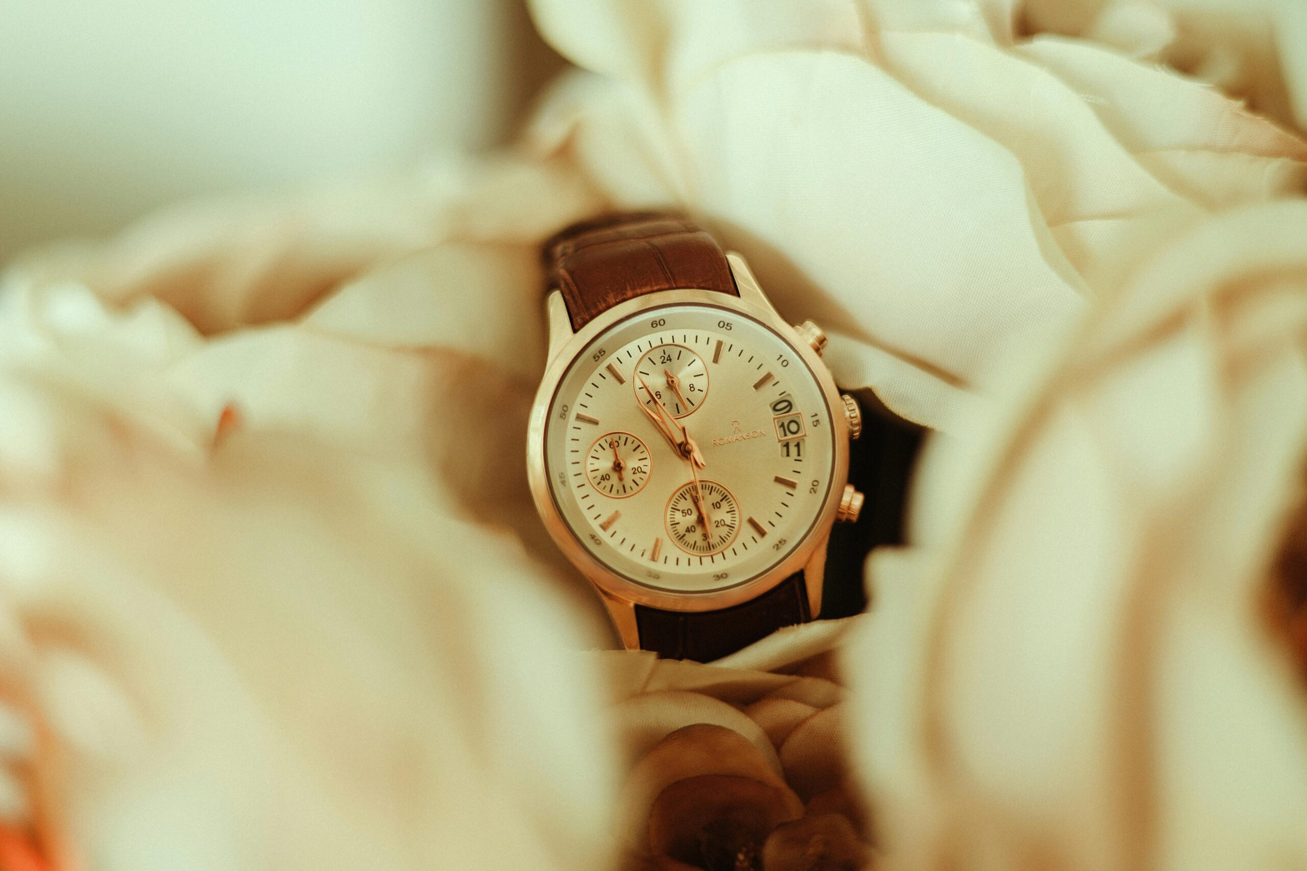 A close-up of a wristwatch encased in delicate, soft-toned flowers, perfect for fashion and elegance themes.